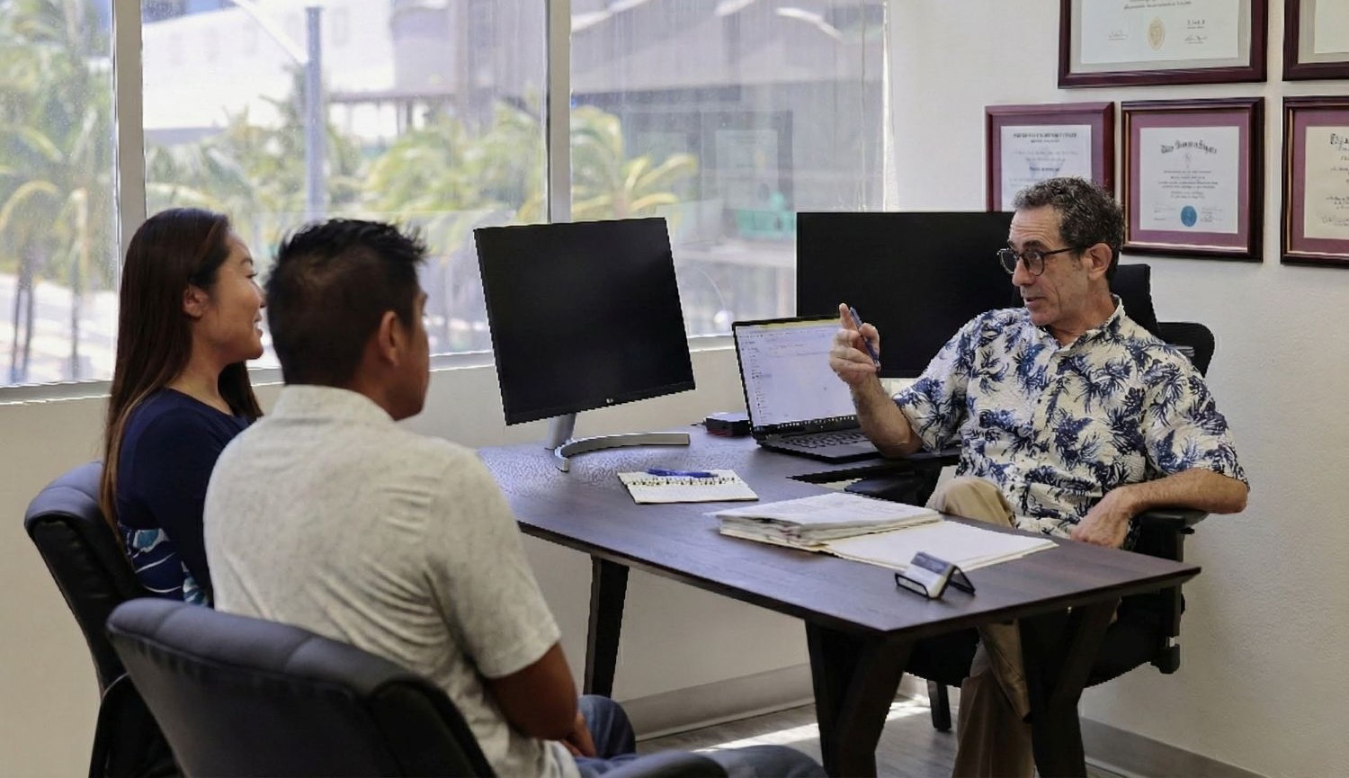 Martin Berger meeting with clients at his Honolulu bankruptcy law office.